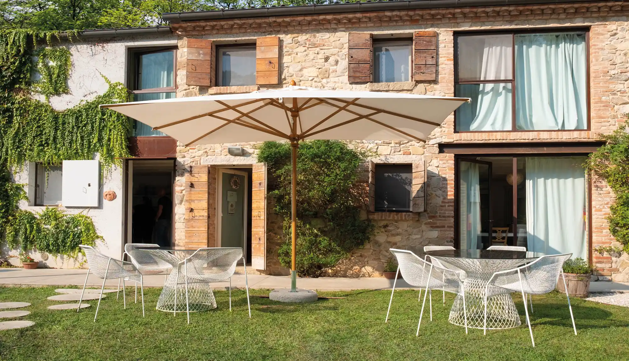 Scolaro Palladio telescopic parasol in a residential setting outside an italian style villa